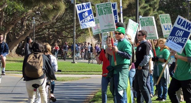 UCSB union workers wield strike signs Wednesday as students pass by on bicycles between classes. The employees were expected to return to work Thursday. (Gina Potthoff / Noozhawk photo)