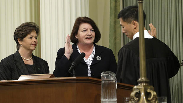 Assemblywoman Toni Atkins (D-San Diego), center, is sworn in as Assembly speaker by California Supreme Court Associate Justice Goodwin Liu, as her spouse, Jennifer LeSar, left, watches at the Capitol on Monday. (Rich Pedroncelli / AP)