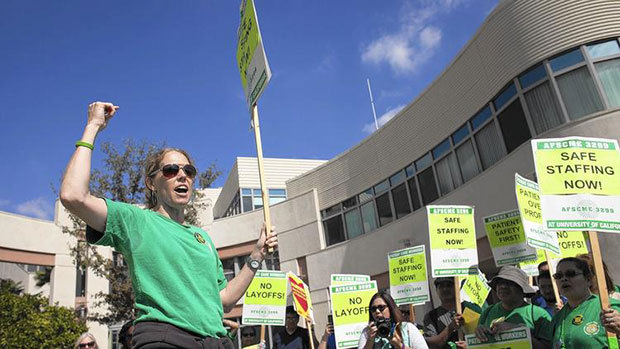 Kathryn Lybarger, president of Local 3299 of the American Federation of State, County and Municipal Employees, a union that represents technicians, assistants and other service workers, gathers supporters Tuesday before marching at UCI Medical Center in Orange to protest layoffs there. (Kevin Chang | Daily Pilot)